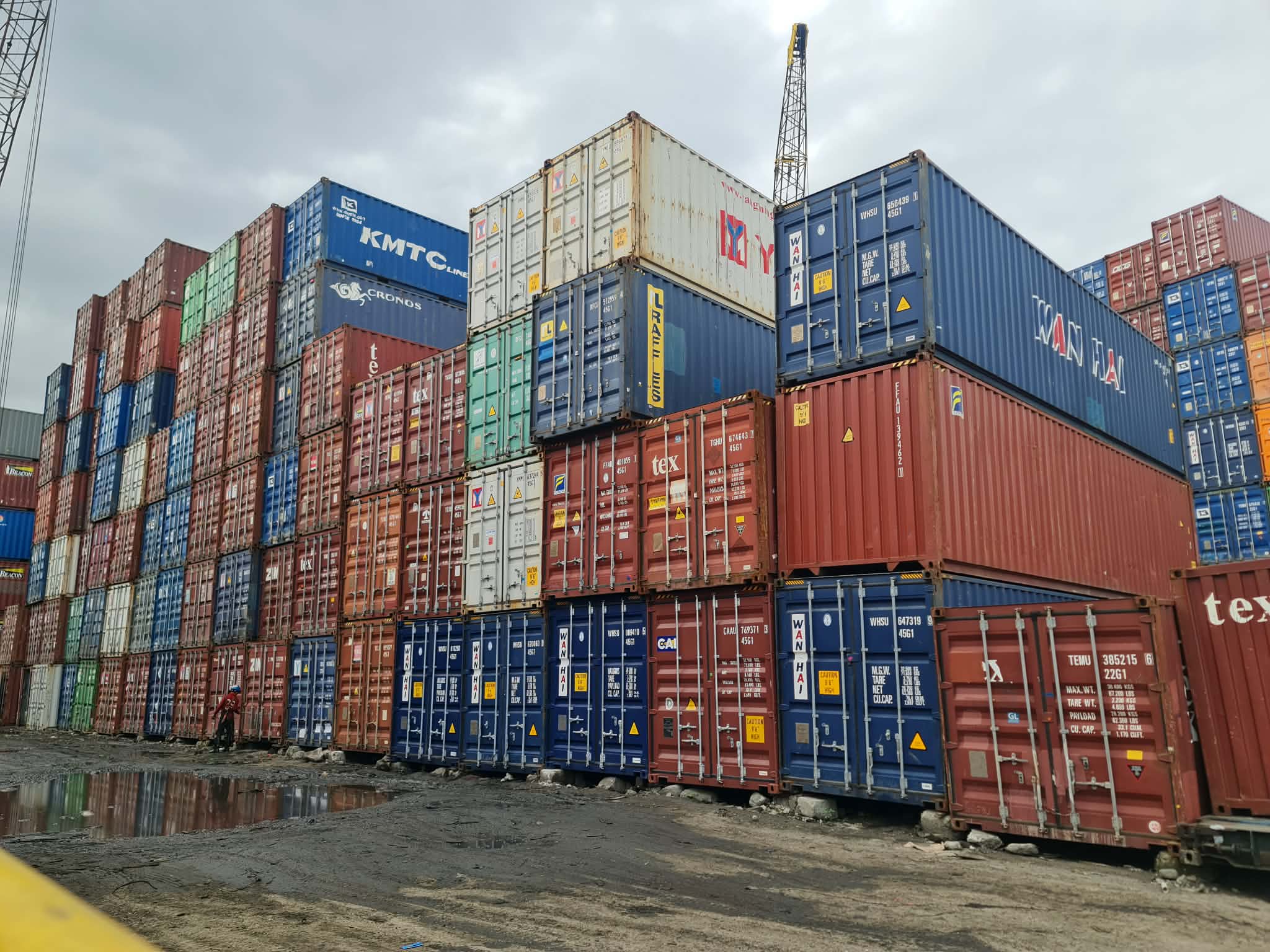 Container yard with puddle reflections and stacked units